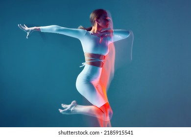 Slim Young Girl Dancing, Turning On Blue Background. Motion Blur, Long Exposure. Contemporary Dance Workout