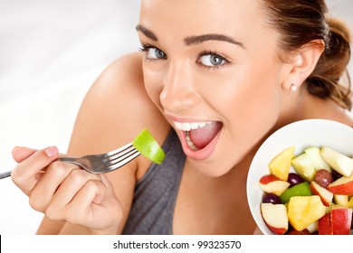 Slim Young Woman Eating Fruit Salad