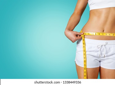 Slim Young Woman Measuring Her Thin Waist