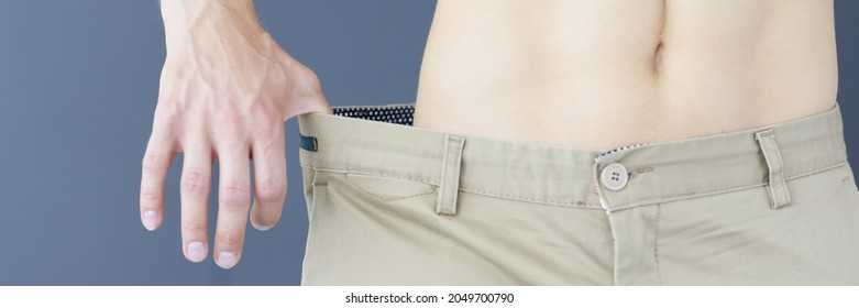 Slimming Muscular Man In Pants That Too Big Closeup