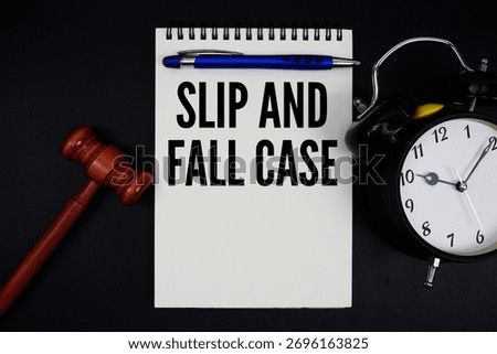Slip and Fall Case text written on notepad with gavel and alarm clock on black background