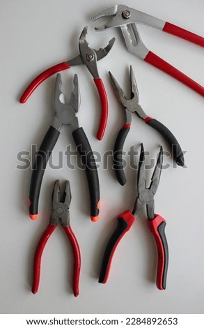 Slip Joint Pliers, Groove Pliers, Needle Nose Pliers And Linesman Pliers Laid Out On White
