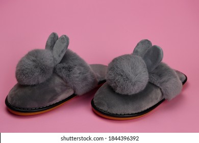 Slippers with fluffy ears, comfortable women's home shoes on a pink background