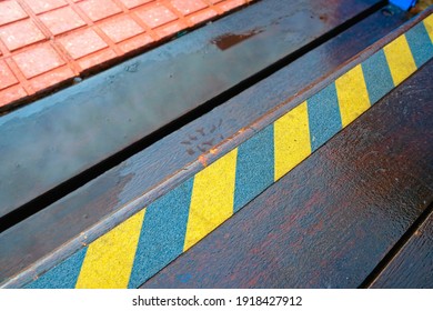 Slippery Pavement And A Warning Tape With Yellow And Black Strips.