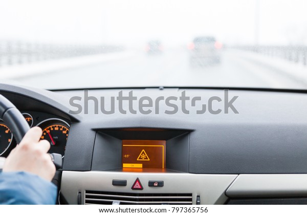 Slippery road warning on car display, car interior\
point of view