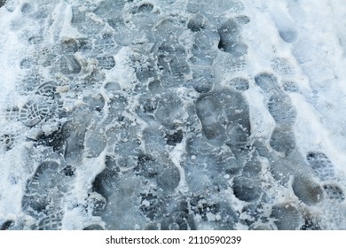 Slippery Sidewalk In Winter Covered With Slush Full Of Footprints