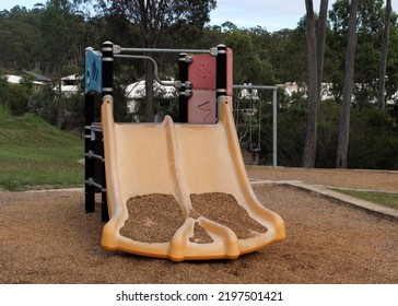 Slippery Slide In A Park Playground Filled With Gravel