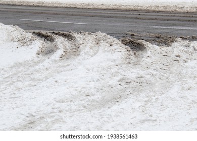 Slippery Slushy Snow With Tire Marks And Ruts At Road Entrance To Highway.