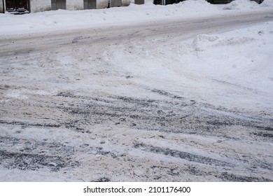 Slippery Snowy City Road During Winter. Difficult Weather Conditions. Street And Sidewalk Under Snow Piles. Dangerous Traffic.