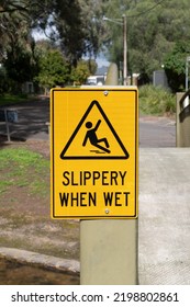 Slippery when wet yellow warning sign on the metal bridge in the park - Shutterstock ID 2198802861