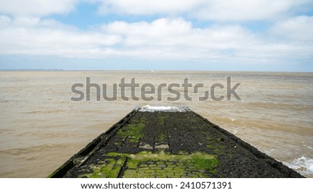 Slipway with slippery moss in the ocean. Cloudy sky. Whitstable kent