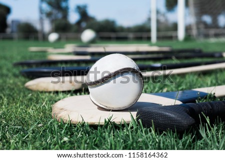 Slither on top of a hurl during hurling practice on a field