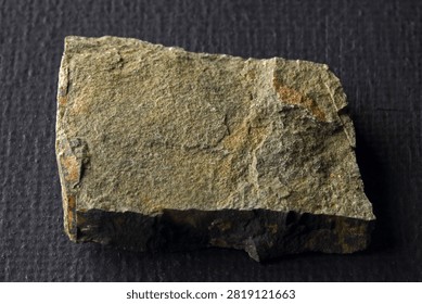SLIVER OF SLATE  WITH FLAT PLANES BEARING PARTIALLY OBSCURED DULL LUSTER