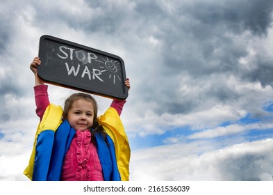 The slogan is no war in children's hands. War in Ukraine. Child with the inscription stop war. Children against war. Peace concept. Ukrainian children. Child wrapped in Ukrainian flag