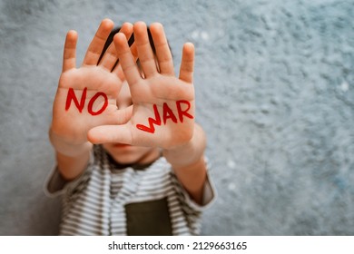 slogan of peace without war is written on the child's hand in red no war. The concept of No war, stop the war, peace