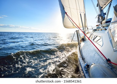 Sloop rigged yacht sailing in an open Baltic sea on a clear day. Close-up view from the deck to the bow, mast and sails. Latvia - Powered by Shutterstock