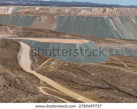 Slopes and platforms of mine waste dump in desert landscape