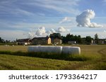 sloping field and hay bales packed in white plastic in Jarvenpaa, Finland