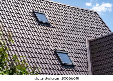 Sloping Roof With Metal Coating Of Residential Building With Windows And Green Trees In Foreground