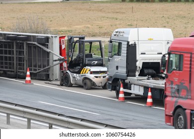Slovenska Bistrica - March 23, 2018: Tow truck workers cleaning wreckage after traffic accident on highway after a small truck lost control and its trailer crashed into the security fence - Shutterstock ID 1060754426