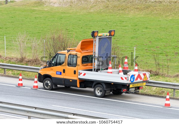 Slovenska\
Bistrica - March 23, 2018: Tow truck workers cleaning wreckage\
after traffic accident on highway after a small truck lost control\
and its trailer crashed into the security\
fence
