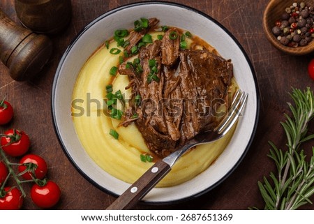 slow cooked beef with mashed potato, wooden background, top view