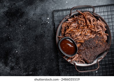 Slow Cooked Pulled Beef, Traditional meat rubbed with spices and smoked in a Texas smoker. Black background. Top view. Copy space.
