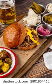 Slow cooked pulled rib beef burger with melted cheese and sides