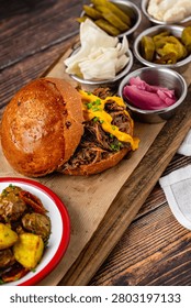 Slow cooked pulled rib beef burger with melted cheese and sides