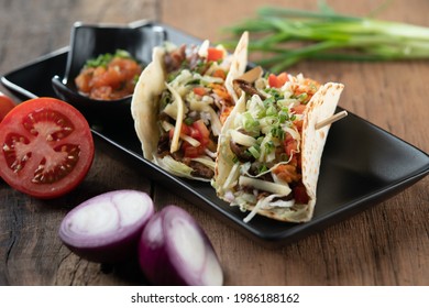 Slow Cooked Short Ribs On Tortillas With A Spring Onion Tomato Salsa Isolated On Wooden Table