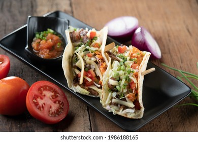 Slow Cooked Short Ribs On Tortillas With A Spring Onion Tomato Salsa Isolated On Wooden Table