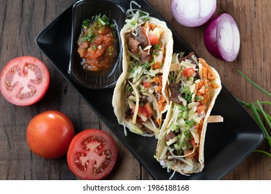 Slow Cooked Short Ribs On Tortillas With A Spring Onion Tomato Salsa Isolated On Wooden Table