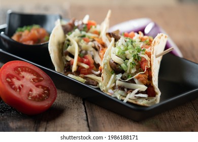 Slow Cooked Short Ribs On Tortillas With A Spring Onion Tomato Salsa Isolated On Wooden Table