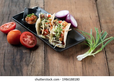 Slow Cooked Short Ribs On Tortillas With A Spring Onion Tomato Salsa Isolated On Wooden Table