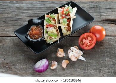 Slow Cooked Short Ribs On Tortillas With A Spring Onion Tomato Salsa Isolated On Wooden Table