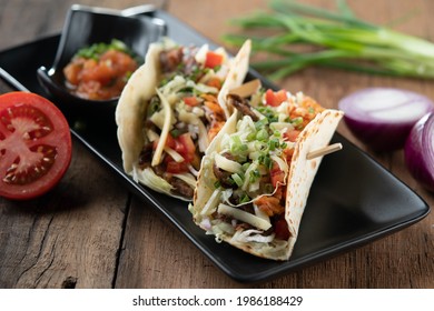 Slow Cooked Short Ribs On Tortillas With A Spring Onion Tomato Salsa Isolated On Wooden Table