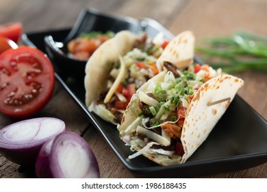 Slow Cooked Short Ribs On Tortillas With A Spring Onion Tomato Salsa Isolated On Wooden Table