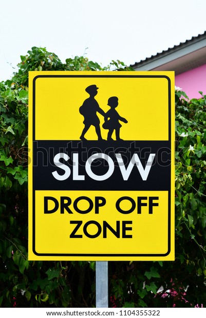 slow down drop off zone warning yellow banner\
traffic sign at the school
