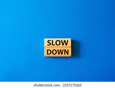 Slow down symbol. Wooden blocks with words Slow down Beautiful blue background. Business and Slow down concept. Copy space.