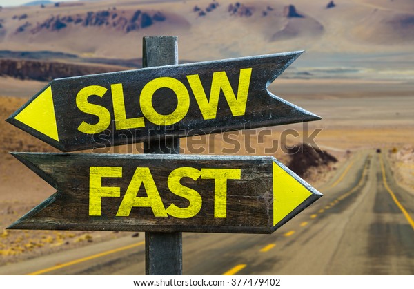 Slow - Fast\
signpost in a desert\
background