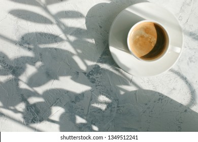 Slow living, cup of coffee in the morning light, sunlight shadow, morning breakfast concept, top view, copy space