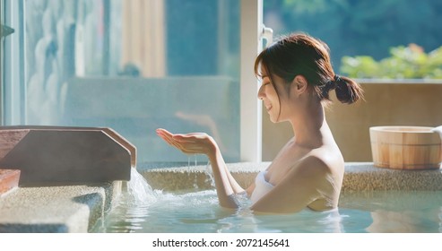 slow motion of asian woman scoop up hot spring by hands to feel the water - Human hand cupped to catch the fresh water