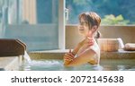 slow motion of asian young woman touch her shoulder while she relaxing sitting in hot spring