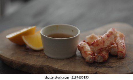 Slow Motion Gimbal Shot Of Crab Leg Meat On A Olive Board With Sweet Lemon And Dip Sauce