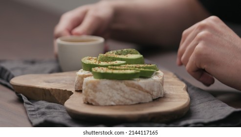 Slow Motion Man Eating Breakfast With Caibatta With Avocado And Cream Cheese And Cup Of Espresso