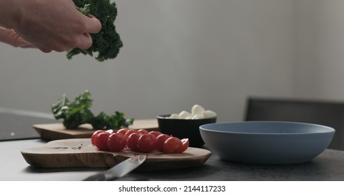 Slow Motion Man Hands Tear Kale Leaves In Blue Bowl On Concrete Surface