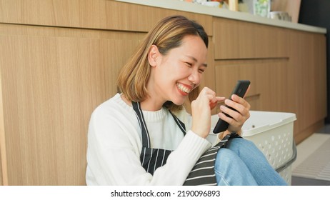 Slow Motion Scene On Young Asian Woman Hold Smartphone To Communicate With Friends And Family Inside Houses Kitchen Room For Social Media Network And Technology Lifestyle Concept