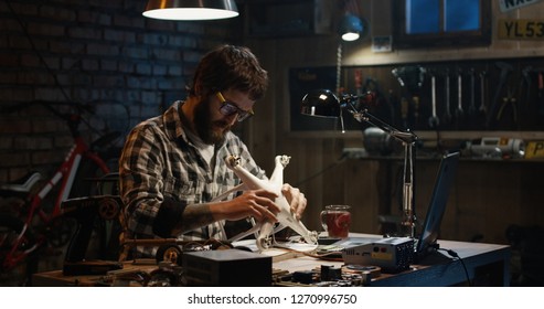 Zeitlupe eines Mannes, der eine Drohne in einer Werkstatt repariert