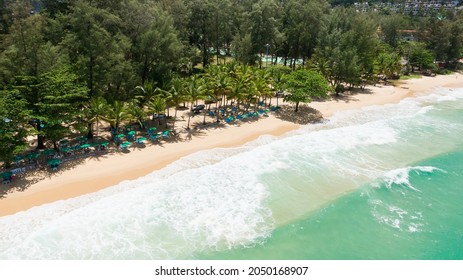 Slow Motion Waves Splash Coastline Green Sea Waters Summer.Beautiful Drone Shot,Umbrella And Chairs Colourful To Sleep And Relax Beach Sunny.Blue Crystal White Sand Beach Nature Tropical Palms Island.