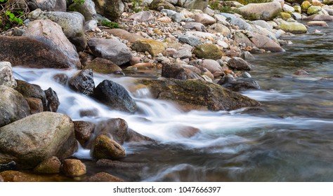 Slow shutter speed image of small waterfall from the gap between rock in the river